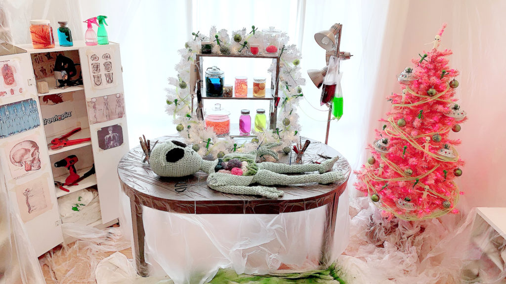 Alien Autopsy Halloween decor with crocheted alien and pink Halloween tree covered in UFOs