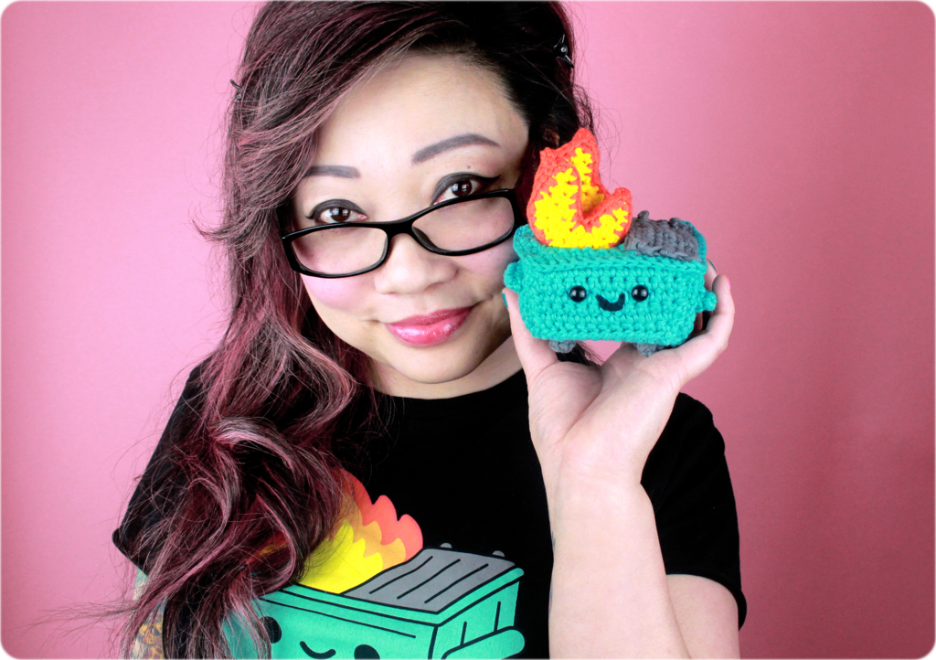 Twinkie Chan and her crocheted dumpster fire, also wearing a black dumpster fire t shirt by 100% Soft